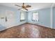 Cozy living room with tile flooring, a ceiling fan, and two windows, near the front door at 5504 60Th N Way, St Petersburg, FL 33709