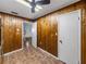 Room featuring wood paneling, tile floors, and two doorways at 5504 60Th N Way, St Petersburg, FL 33709