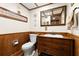 Charming bathroom featuring wood paneling, decorative mirror, and a unique wood vanity with a white sink at 5701 Mariner St # 606, Tampa, FL 33609