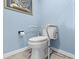 Compact toilet with safety rails in a small powder room, providing accessibility and convenience within a cozy space at 5701 Mariner St # 606, Tampa, FL 33609