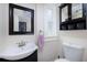 Well-lit half bathroom with a black vanity, modern sink, mirror, and storage cabinet at 6342 5Th N Ave, St Petersburg, FL 33710