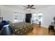 Cozy bedroom featuring hardwood floors, a ceiling fan, and plenty of natural light from the windows at 6342 5Th N Ave, St Petersburg, FL 33710