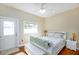 Bright bedroom with a white frame bed, a white bench, and a door leading to the outside at 6342 5Th N Ave, St Petersburg, FL 33710