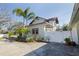 Charming two-story home featuring fresh landscaping, a white fence, and a concrete drive at 6342 5Th N Ave, St Petersburg, FL 33710