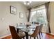 Elegant dining room with a glass-top table set for six, hardwood floors, and a large window at 7510 Red Mill Cir, New Port Richey, FL 34653