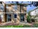 Exterior view of a two-story townhouse with a sliding glass door and small patio at 7510 Red Mill Cir, New Port Richey, FL 34653