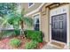 Welcoming entrance to the home with lush landscaping, including a palm tree, creating a warm and inviting curb appeal at 7510 Red Mill Cir, New Port Richey, FL 34653