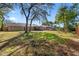 The backyard features green trees, a swing hanging from a branch, and is surrounded by a wooden fence at 8449 Valmora St, Spring Hill, FL 34608