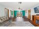 Bright living room with wood flooring, a stylish gray sofa, and large windows at 8449 Valmora St, Spring Hill, FL 34608