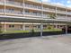 Exterior view of condo building showcasing covered carport parking and manicured lawn at 9950 62Nd N Ter # 203, St Petersburg, FL 33708