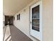 Exterior view of condo unit 203 with storm door along a shared walkway at 9950 62Nd N Ter # 203, St Petersburg, FL 33708