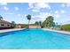 Outdoor pool area with ample seating, palm trees, and blue skies create a relaxing and inviting atmosphere at 9950 62Nd N Ter # 203, St Petersburg, FL 33708