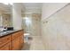 A bright bathroom features a glass-enclosed shower, granite-topped vanity, and tiled floors at 10159 Hernando Ridge Rd, Weeki Wachee, FL 34613