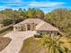 A beautiful single-story home featuring verdant landscaping, circular driveway, and charming facade at 10159 Hernando Ridge Rd, Weeki Wachee, FL 34613