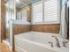 Clean bathroom featuring a soaking tub and glass shower with tiled walls, as well as a window for natural light at 10193 Grand Oak Cir, Madeira Beach, FL 33708