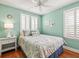 Calming bedroom with hardwood floors, features shuttered windows and an accent wall in a light green color at 10193 Grand Oak Cir, Madeira Beach, FL 33708