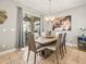 Dining room features a modern light fixture, slider to the porch, and neutral tones at 10193 Grand Oak Cir, Madeira Beach, FL 33708