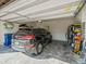 Attached garage providing ample space for parking, with a black car, shelving, and a blue trash can at 10193 Grand Oak Cir, Madeira Beach, FL 33708