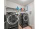 Functional laundry room with a modern washer and dryer set, shelves and tile flooring at 10193 Grand Oak Cir, Madeira Beach, FL 33708