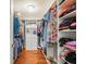 Organized walk-in closet with hardwood floors features built-in shelving and a chest of drawers for optimal storage at 10193 Grand Oak Cir, Madeira Beach, FL 33708