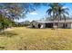 Spacious backyard with green lawn, mature trees, and a privacy hedge at 10222 95Th St, Seminole, FL 33777