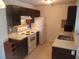 Kitchen featuring tile floors, white appliances, and dark cabinets at 10265 Gandy N Blvd # 1806, St Petersburg, FL 33702