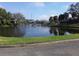 Community pond with bridge access, surrounded by mature trees and green lawns at 10265 Gandy N Blvd # 1806, St Petersburg, FL 33702