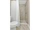 Tiled shower with white shower curtain and low-flow toilet at 13526 Alberta Ave, Port Charlotte, FL 33981