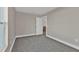 Neutral bedroom with gray carpet, white trim, and white door at 13526 Alberta Ave, Port Charlotte, FL 33981