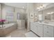 Spa-like bathroom featuring a soaking tub, a glass-enclosed shower, and dual vanities at 17020 Cape Horn Blvd, Punta Gorda, FL 33955