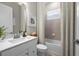 Bright bathroom featuring patterned shower curtain, white cabinets, and a large mirror at 17020 Cape Horn Blvd, Punta Gorda, FL 33955