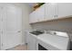 A well-organized laundry room with overhead storage, a sink, and a washer and dryer at 17020 Cape Horn Blvd, Punta Gorda, FL 33955