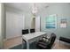 Bright home office with modern light fixture, neutral walls, desk, and carpeted floors at 17020 Cape Horn Blvd, Punta Gorda, FL 33955