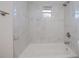 Bright bathroom featuring white marble tile and a shower-tub combo at 17319 Terry Ave, Port Charlotte, FL 33948