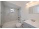 Bright bathroom featuring white marble tile, a gray vanity, and modern fixtures at 17319 Terry Ave, Port Charlotte, FL 33948