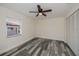 Bedroom with modern gray floors, a ceiling fan, and a bright window at 17319 Terry Ave, Port Charlotte, FL 33948