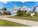 Two-story home with blue exterior, well-manicured landscaping, and concrete sidewalk at 18329 Roseate Dr, Lutz, FL 33558