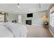 Bright and airy main bedroom with a view to the ensuite bathroom and a tv at 18329 Roseate Dr, Lutz, FL 33558