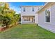 The manicured back yard has a lush green lawn, palm trees and views of the home's back porch and upper stories at 243 28Th N Ave, St Petersburg, FL 33704