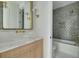 Bathroom with marble countertop vanity, brass fixtures and gray tiled shower/tub at 243 28Th N Ave, St Petersburg, FL 33704