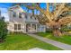 Charming two-story home with inviting front porch, large shade tree, and lush lawn at 243 28Th N Ave, St Petersburg, FL 33704