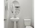 Simple half bathroom with a pedestal sink, white toilet, and neutral decor at 25993 Woven Wicker Bnd, Lutz, FL 33559