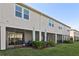 Rear exterior view of condo shows screened patios and lawn area at 25993 Woven Wicker Bnd, Lutz, FL 33559