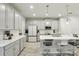 Bright, modern kitchen with stainless steel appliances, white cabinetry, and a large center island at 25993 Woven Wicker Bnd, Lutz, FL 33559