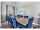 Dining room with large wooden table, blue upholstered chairs, and scenic views from window at 330 6Th Ave, Indian Rocks Beach, FL 33785