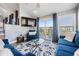 Living room with blue furniture, patterned rug, TV, and balcony access with scenic views at 330 6Th Ave, Indian Rocks Beach, FL 33785