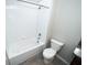 Full bathroom with white tiled tub and shower combination, toilet, and tiled floors at 3808 Cat Mint St, Tampa, FL 33619