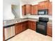 Open kitchen featuring stainless steel dishwasher, granite countertops, and cherry wood cabinets at 3808 Cat Mint St, Tampa, FL 33619