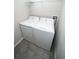 A well-organized laundry room with a white washer and dryer set and tiled floor at 3808 Cat Mint St, Tampa, FL 33619