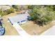 Aerial view of a charming blue single-story home featuring a long driveway and front lawn at 39035 Citadel Cir, Zephyrhills, FL 33542